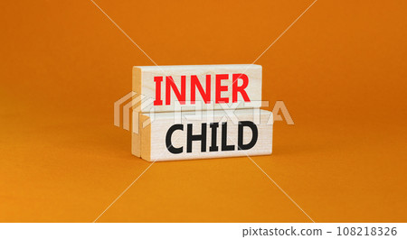 Inner child symbol. Concept words Inner child on beautiful wooden block. Beautiful orange table orange background. Psychological, motivational inner child concept. Copy space. 108218326