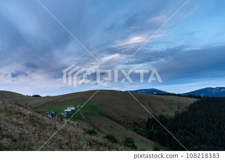Morning landscape in the mountains. Dawn in the mountains. Rural huts on top of the mountain. Cloudy sky over the village. Morning landscape in the mountains. Dawn in the mountains. Rural huts on top of the mountain. Cloudy sky over the village. 108218383