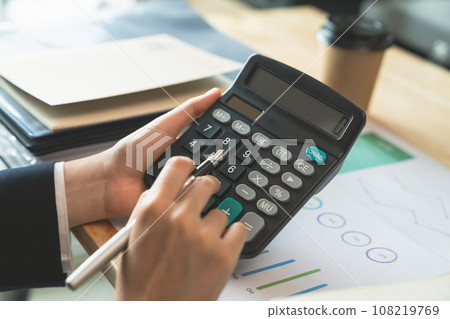 Accountant using calculator with financial documents on desk office. 108219769