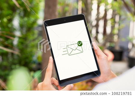 Hand holding digital tablet with showing email send complete. Hand holding digital tablet with showing email send complete. 108219781