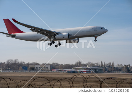 Side view of an airplane landing against a blue sky. Widescreen.  108220308