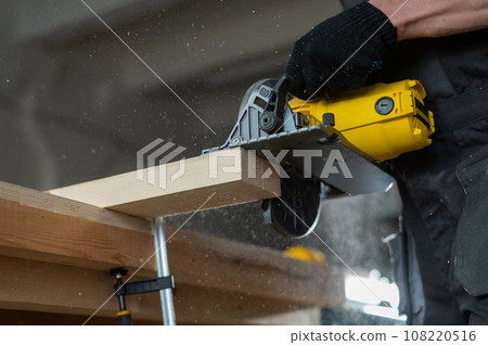 Master cuts the board with a circular saw in the workshop. Close-up of a carpenter's hands at work. Master cuts the board with a circular saw in the workshop. Close-up of a carpenter's hands at work. 108220516