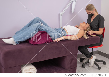 Caucasian woman on eyelash extension procedure. Caucasian woman on eyelash extension procedure. 108220691