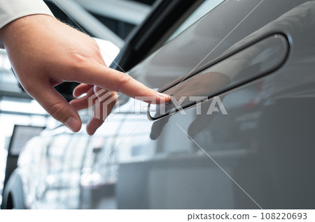 A man opens a car door with a fingerprint. Integrated handle. A man opens a car door with a fingerprint. Integrated handle. 108220693