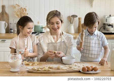 Caring mom teach to cute kids cooking in kitchen 108220703