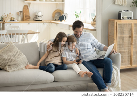 Happy family use electronic devices at home Happy family use electronic devices at home 108220714