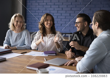 Cheerful team discuss creative ideas in office Cheerful team discuss creative ideas in office 108220863