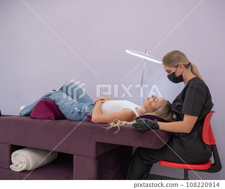 Caucasian woman on eyelash extension procedure. Caucasian woman on eyelash extension procedure. 108220914