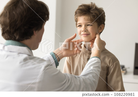 Young male doctor check little patient tonsils during visit Young male doctor check little patient tonsils during visit 108220981