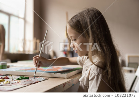 Cute little girl painting pictures in art studio 108221072