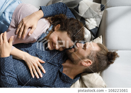 Peaceful cute millennial dating couple lying together on couch 108221081