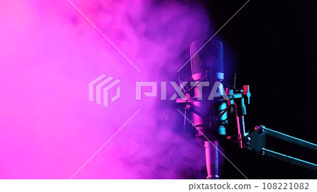 Professional microphone in pink smoke on a black background. 108221082