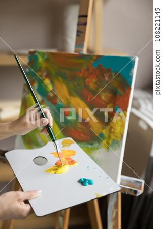 Female painter create picture, mixing colors, working in workshop 108221145