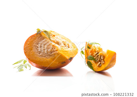 A piece of ripe orange pumpkin with seeds on a white background. 108221332