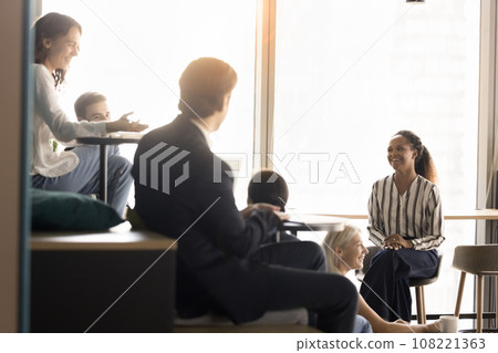 Positive team with young female leader brainstorming in meeting room Positive team with young female leader brainstorming in meeting room 108221363
