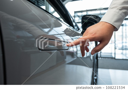 A man opens a car door with a fingerprint. Integrated handle. A man opens a car door with a fingerprint. Integrated handle. 108221534