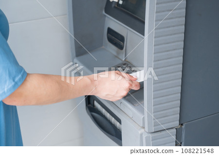 Close-up of woman's hands using ATM with contactless nfs access.  108221548