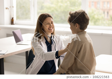 Positive female doctor examining little boy in clinic 108221563