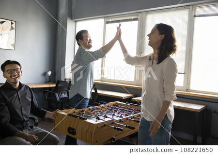 Coworkers having fun, playing table football in office Coworkers having fun, playing table football in office 108221650