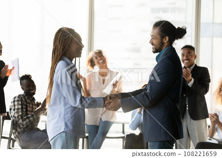Smiling African American business partners shaking hands at meeting Smiling African American business partners shaking hands at meeting 108221659