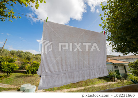 Big white towel waving near house - at sunny day 108221660