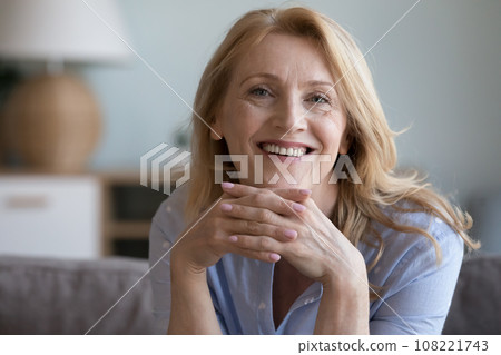 Cheerful blonde mature 60s lady home head shot portrait 108221743