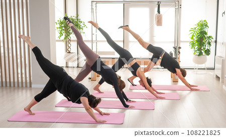 Three woman and man doing yoga in a fitness center.  108221825