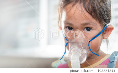 Kid girl making makes inhalation nebulizer steam sick cough at home, Asian Child using nebulizer mask equipment alone have smoke, stuffy nose and runny, oxygen spray inhaler therapy, Health medical 108221853