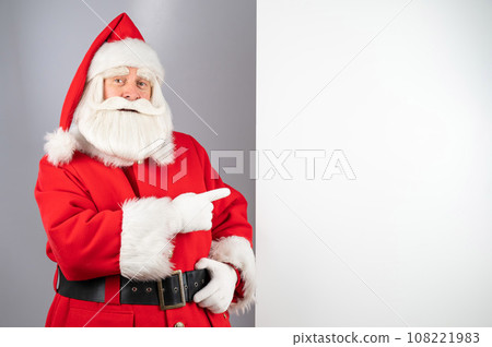 Santa claus points to an empty space. Christmas advertisement. 108221983