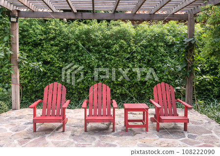 Three red wooden chairs decor in tropical garden of restaurant Three red wooden chairs decor in tropical garden of restaurant 108222090