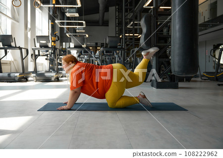 Overweight woman doing exercise with pleasure and motivation Overweight woman doing exercise with pleasure and motivation 108222962