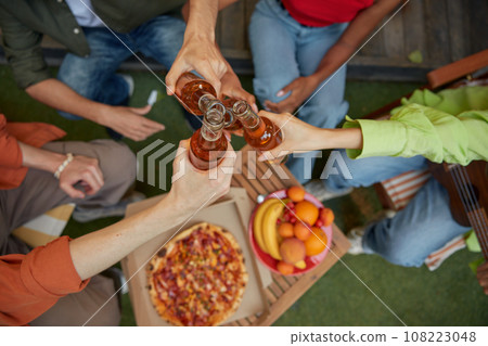 Friends clinking beer bottles view from top 108223048