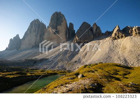 Rocky battlements of Three Peaks and small mountain lake in Sexten Dolomites Rocky battlements of Three Peaks and small mountain lake in Sexten Dolomites 108223323