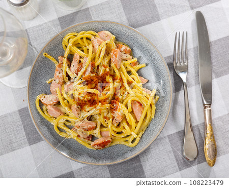 Appetizing spaghetti with sausage served on platter Appetizing spaghetti with sausage served on platter 108223479