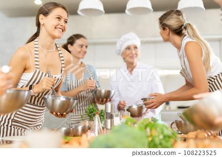 Young female visitor has nice conversation with person facing buddy vis-a-vis at culinary courses 108223525