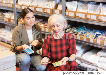 Elderly woman and young woman choose shade of paint from palette 108223579