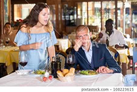 Unhappy couple quarreling during dinner at restaurant Unhappy couple quarreling during dinner at restaurant 108223615