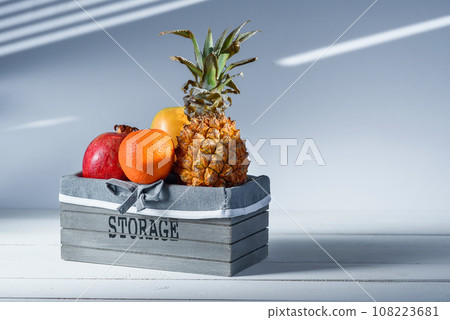 Fresh fruits in grey wooden box with inscription Storage. 108223681