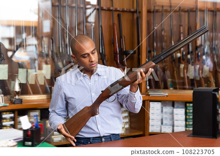 Portrait of an arms shop salesman with a battle winchester in his hands 108223705