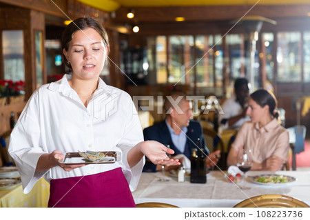 Woman waiter demonstrating her upset with small tip Woman waiter demonstrating her upset with small tip 108223736