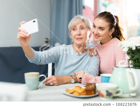 Senior mother and adult daughter taking selfie at home Senior mother and adult daughter taking selfie at home 108223876