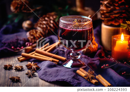 Christmas red mulled wine in a cup with cinnamon sticks, orange slices and winter decorations on wooden background Christmas red mulled wine in a cup with cinnamon sticks, orange slices and winter decorations on wooden background 108224393