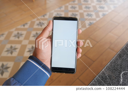 young man hand using smart phone with green screen at cafe young man hand using smart phone with green screen at cafe 108224444