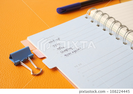 writing on a daily planner on table. writing on a daily planner on table. 108224445