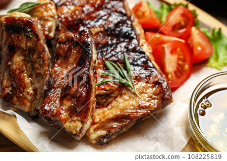 Delicious grilled ribs with rosemary on table, closeup Delicious grilled ribs with rosemary on table, closeup 108225819