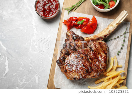 Delicious grilled ribeye steak served on light grey marble table, flat lay. Space for text Delicious grilled ribeye steak served on light grey marble table, flat lay. Space for text 108225821