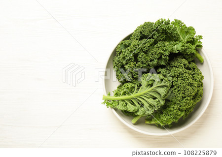 Fresh kale leaves on white wooden table, top view. Space for text 108225879