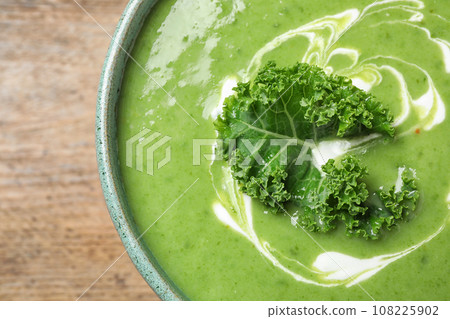 Tasty kale soup on wooden table, top view 108225902