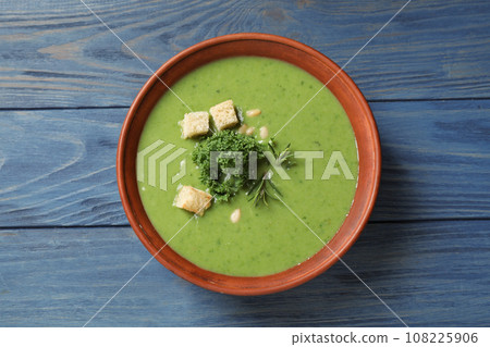 Tasty kale soup with croutons on blue wooden table, top view 108225906