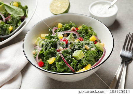 Tasty fresh kale salad on grey table, closeup Tasty fresh kale salad on grey table, closeup 108225914